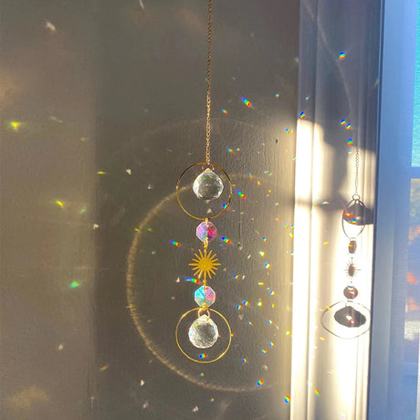 Decorative hanging crystal with sun design on a window