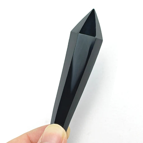 Black geometric object held by a hand against a white background