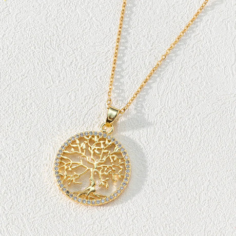 Gold necklace with a tree of life pendant on a light gray background