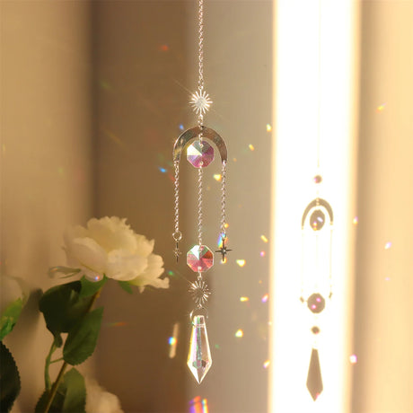 Crystal hanging ornament with rainbow effect in front of a white flower