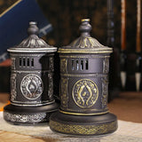 Decorative black and gold containers with intricate designs on a wooden surface.