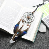 Dreamcatcher with feathers on an open book