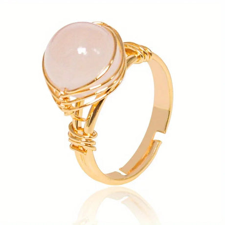 Gold ring with a pink stone on a white background