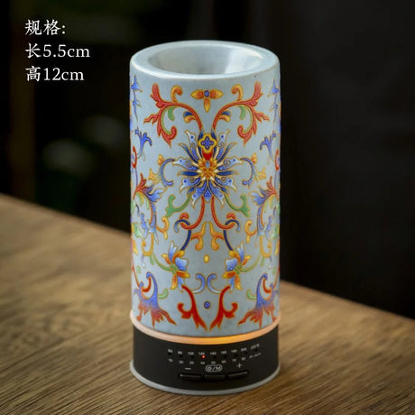 Decorative cylindrical lantern with floral patterns on a wooden surface