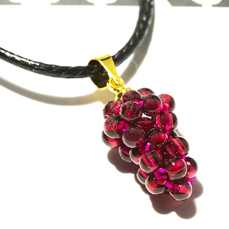 Necklace with a red grape cluster pendant on a white background