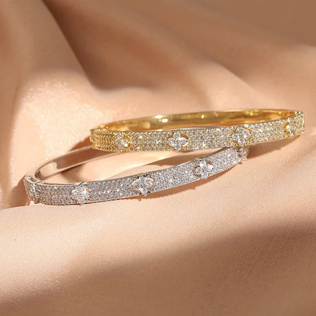Two diamond-encrusted bracelets on a beige fabric background