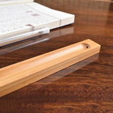 Wooden tool on a wooden surface with a book in the background