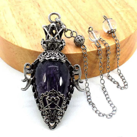 Purple amethyst pendant with silver chain on a wooden block