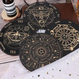 Set of black and gold tarot card coasters on a wooden surface.
