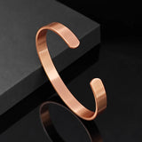 Rose gold bracelet on a black reflective surface