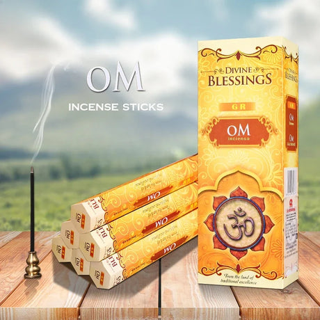 Box of Divine Blessings incense sticks with incense sticks and a holder on a wooden surface with a scenic background.