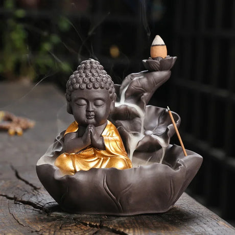 Buddha-shaped incense burner with incense sticks on a dark background