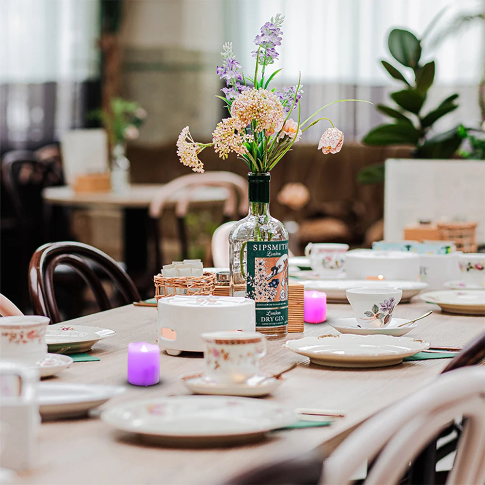 Dining table set with tea cups, a bottle of Sipsmith gin, and floral arrangement.