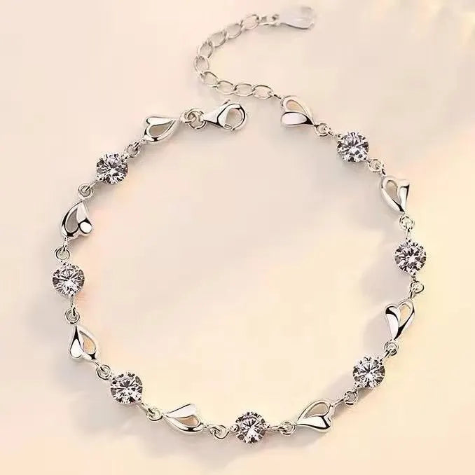 Silver bracelet with crystal stones on a light beige background