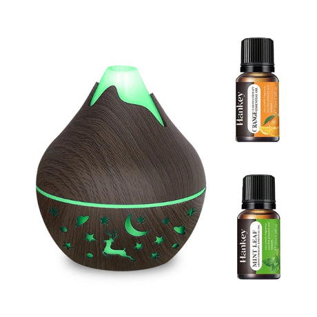 Wooden diffuser with green accents and two bottles of Hankey essential oils on a white background