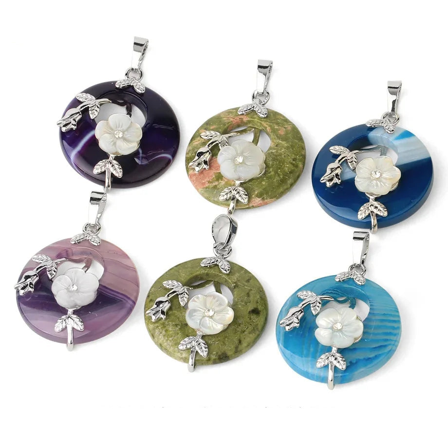 Set of colorful stone pendants with floral designs on a white background