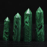 Set of four green crystal-like structures on a dark background
