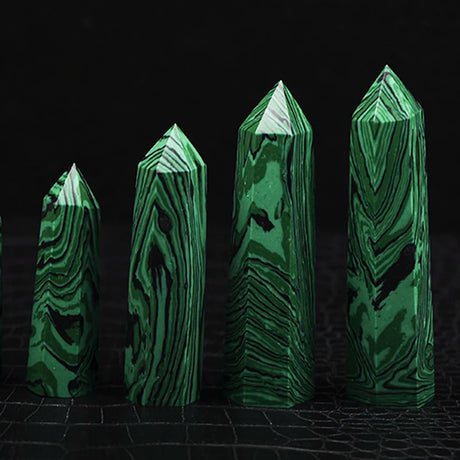 Set of four green crystal-like structures on a dark background