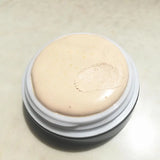 Cosmetic cream in a round container on a light background