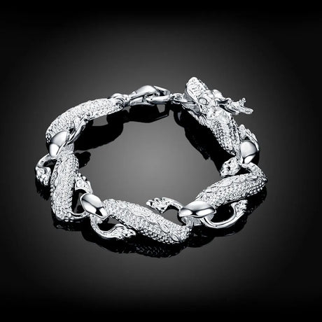 Silver bracelet with dragon design on a black background