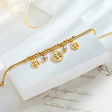 Gold bracelet with tree of life charms on a white surface