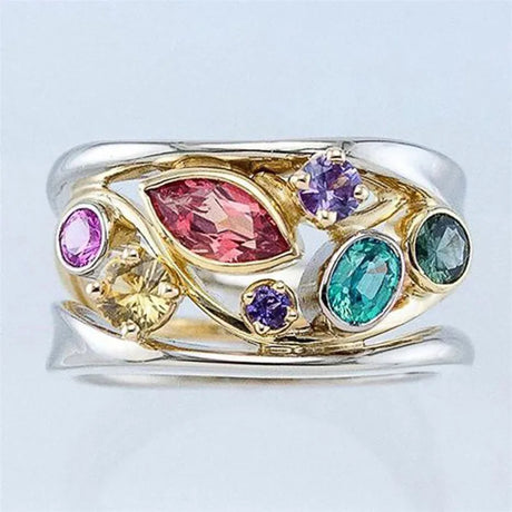 Gold ring with colorful gemstones on a light gray background