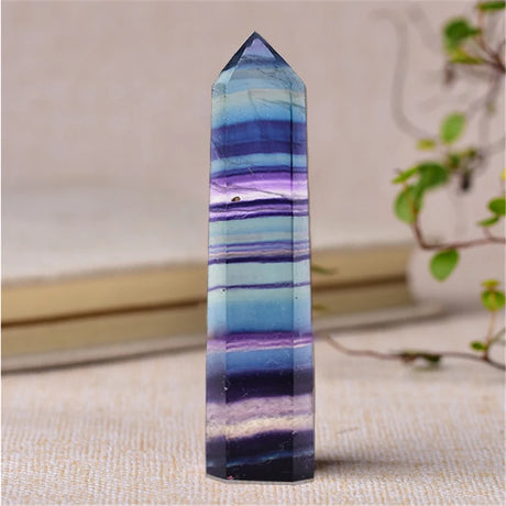 Multicolored crystal tower on a textured surface with a blurred background
