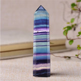Multicolored crystal tower on a textured surface with a blurred background