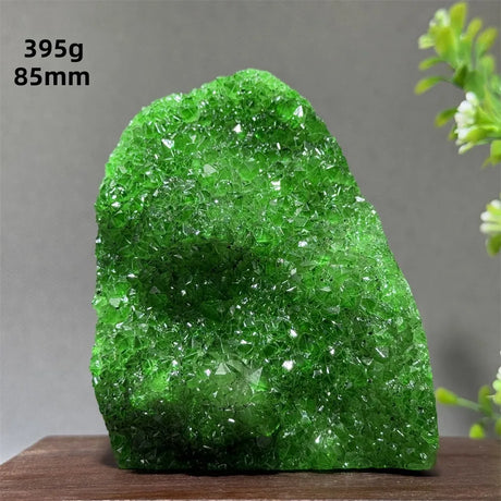 Green crystal rock on a wooden surface with a gray background