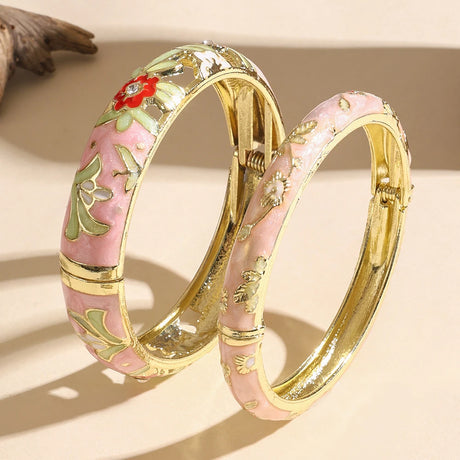 Two decorative bangles with floral designs on a beige background