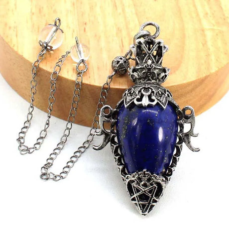 Blue stone pendant with silver chain on a wooden surface