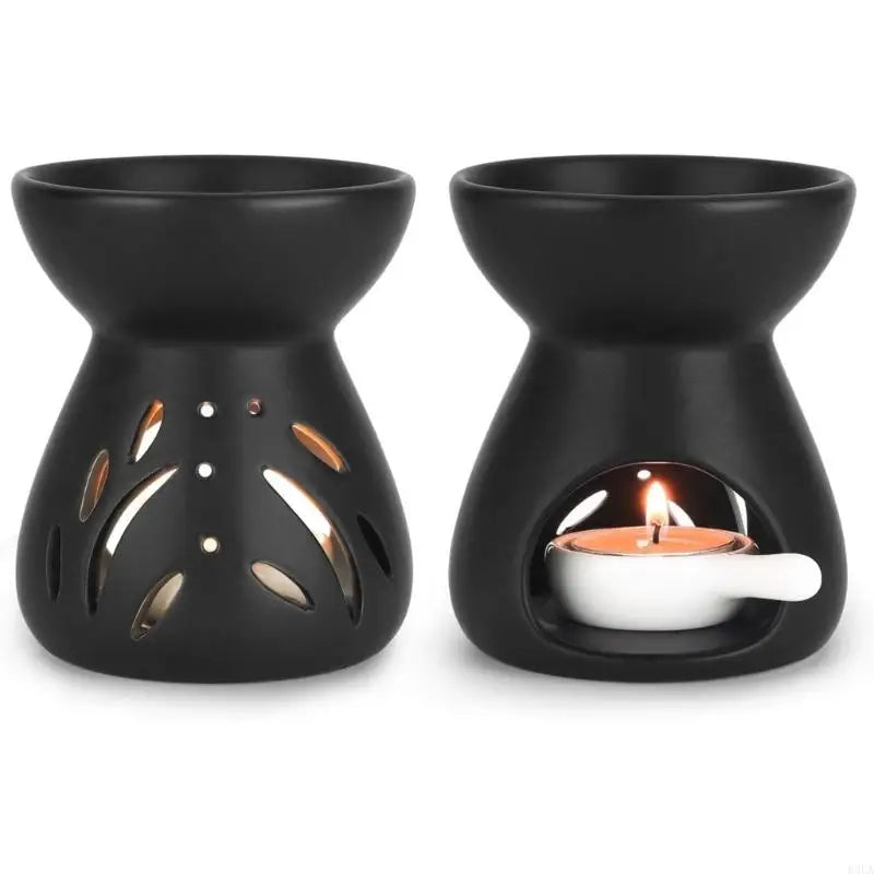 Two black ceramic oil burners with one lit candle inside on a white background