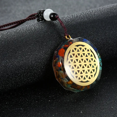 Decorative pendant with gold geometric design on a dark surface