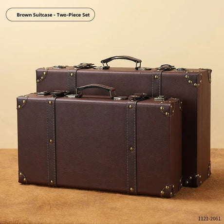 Two brown suitcases with gold accents on a beige background
