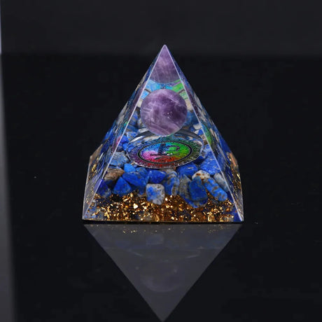 Pyramid-shaped crystal with embedded stones on a black background