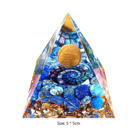 Crystal pyramid with blue stones and a gold sphere on a white background