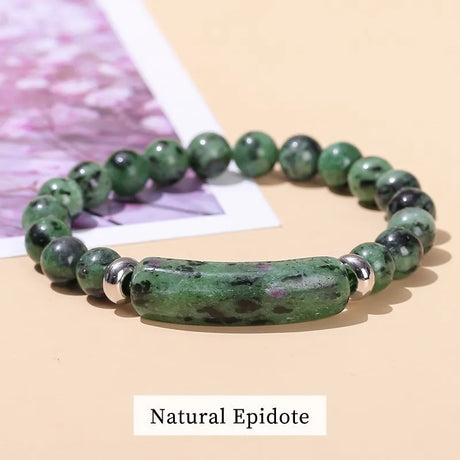 Green beaded bracelet with a large natural stone on a beige surface