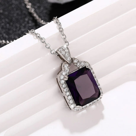 Purple gemstone necklace with silver chain on a white surface