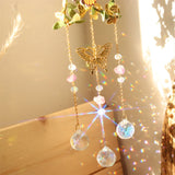 Decorative hanging with crystal balls and butterfly charm on a wooden surface.