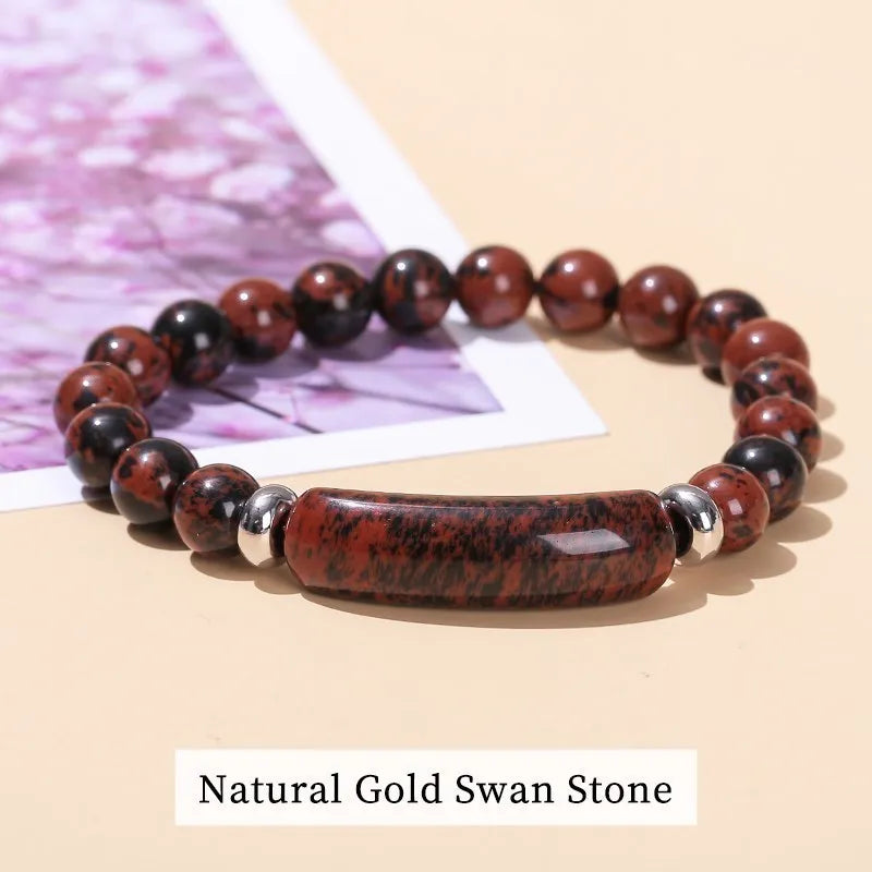 Bracelet with natural gold swan stone beads on a beige surface