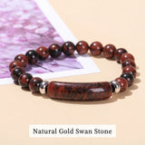 Bracelet with natural gold swan stone beads on a beige surface