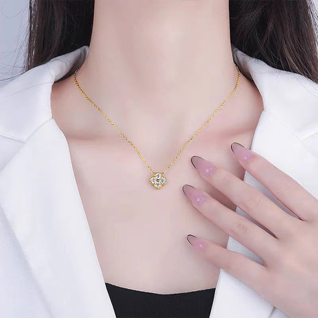 Gold necklace with a heart-shaped pendant worn by a person