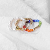 Set of colorful beaded bracelets on a white fabric background