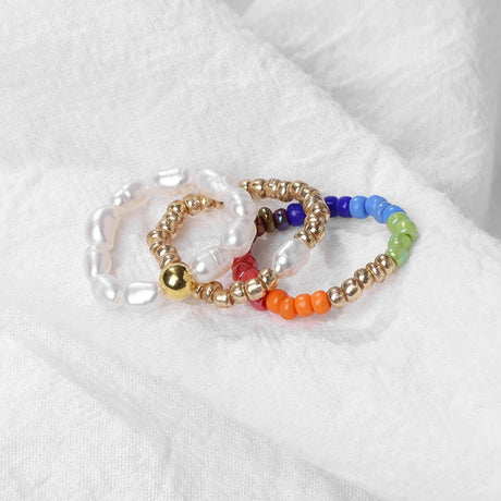 Set of colorful beaded bracelets on a white fabric background