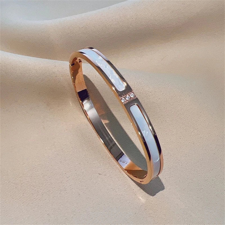 Rose gold bracelet with a subtle design on a beige fabric background
