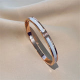 Rose gold bracelet with a subtle design on a beige fabric background