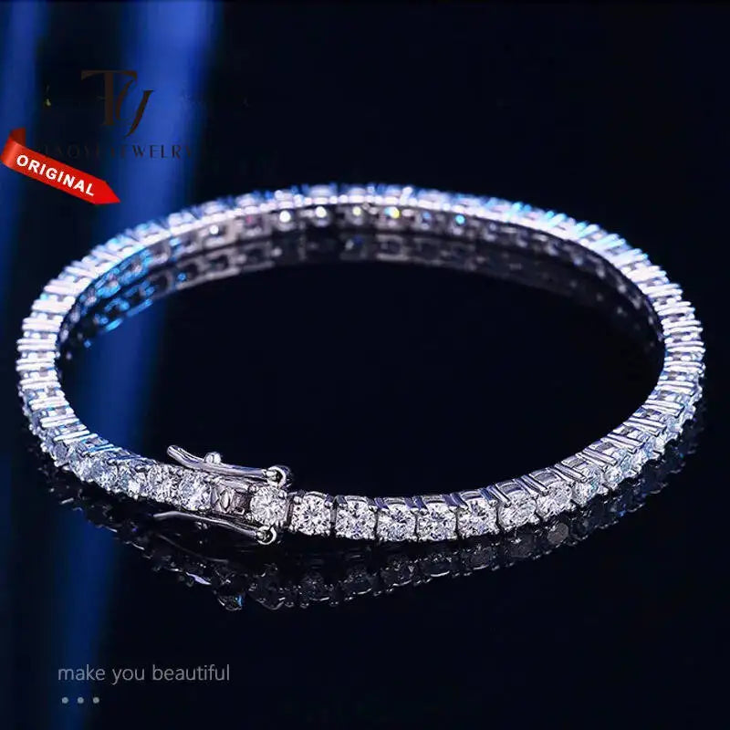 Silver bracelet with clear stones on a dark background, branded 'TJ'.