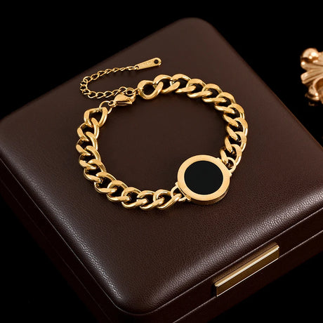 Gold chain bracelet on a dark brown box