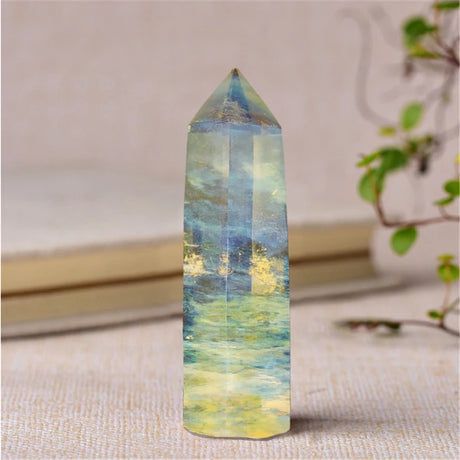 Multicolored crystal tower on a textured surface with a blurred background