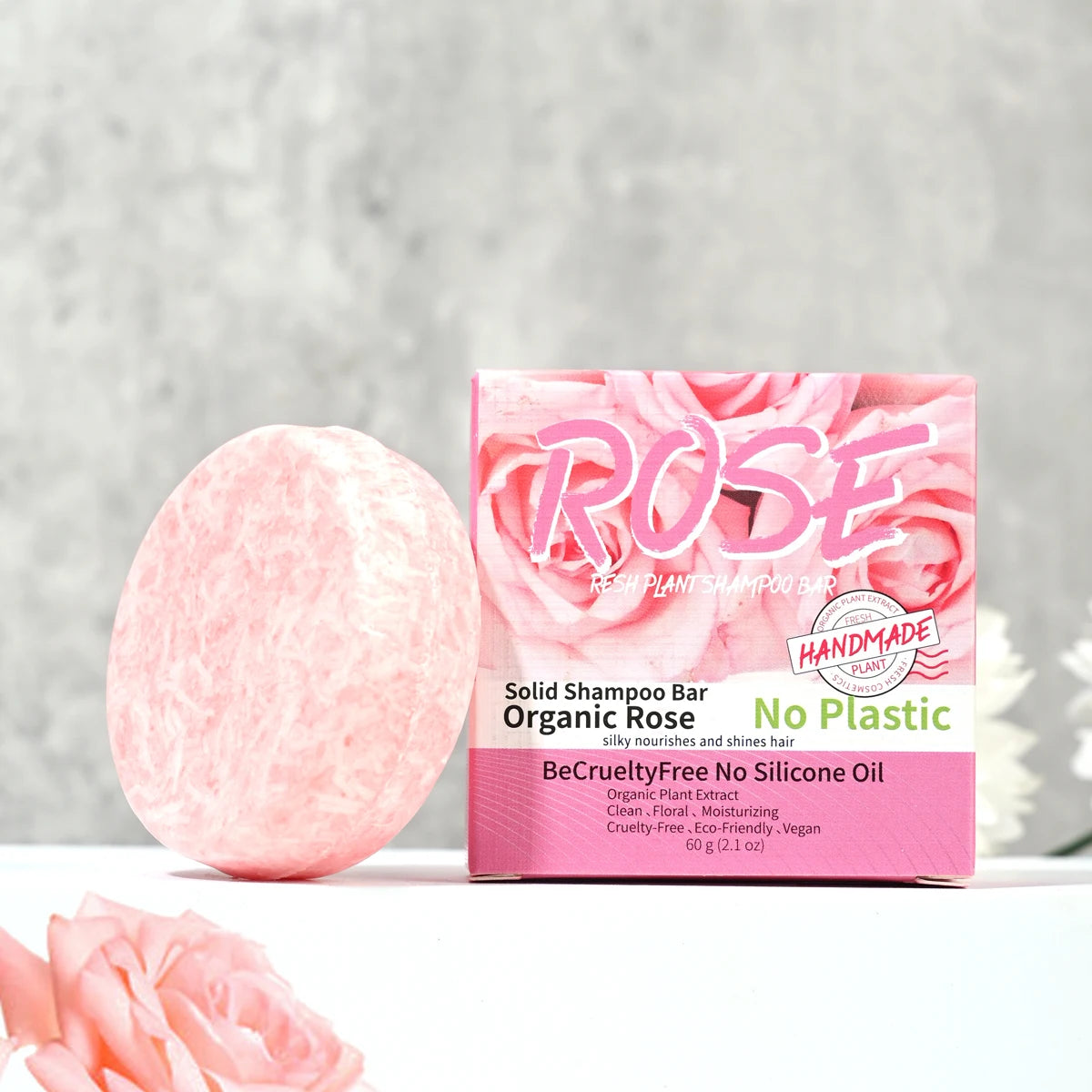 Pink solid shampoo bar with packaging labeled 'Rose' on a light gray background